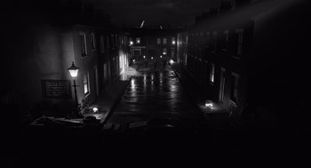 Movie still from “Belfast” (2021), directed by Kenneth Branagh – An alley way in the dark lit by street lamps; Extreme Wide shot, High angle