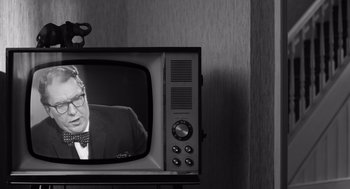 Movie still from “Belfast” (2021), directed by Kenneth Branagh – An old television with a man on the screen; Close Up shot, Over the shoulder angle