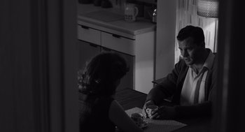 Movie still from “Belfast” (2021), directed by Kenneth Branagh – A man and a woman sitting at a table; Medium shot, Over the shoulder angle