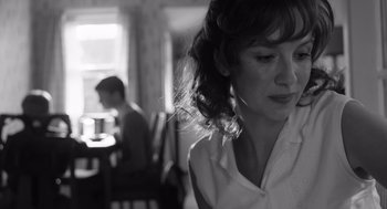 Movie still from “Belfast” (2021), directed by Kenneth Branagh – A black - and - white photo of a woman in front of a table; Close Up shot, Over the shoulder angle