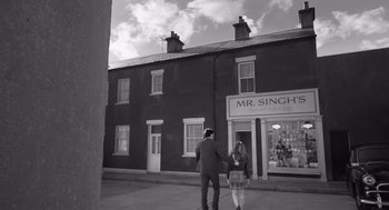 Movie still from “Belfast” (2021), directed by Kenneth Branagh – A man and a woman walking down a street; Wide shot, Low angle