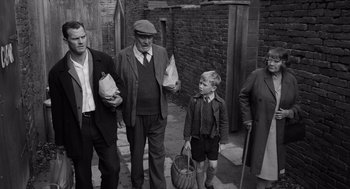 Movie still from “Belfast” (2021), directed by Kenneth Branagh – An old black and white photo of a group of people; Medium shot, High angle