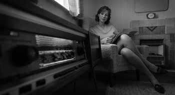 Movie still from “Belfast” (2021), directed by Kenneth Branagh – A woman sitting in a chair in front of an oven; Medium shot, Low angle