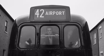 Movie still from “Belfast” (2021), directed by Kenneth Branagh – A black and white photo of a man on a bus; Medium shot, Low angle