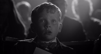 Movie still from “Belfast” (2021), directed by Kenneth Branagh – A young boy wearing a suit and bow tie; Close Up shot, Low angle