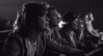 Movie still from “Belfast” (2021), directed by Kenneth Branagh – A group of people sitting next to each other in a room; Close Up shot, Low angle