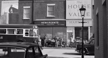 Movie still from “Belfast” (2021), directed by Kenneth Branagh – A black and white photo of people on the sidewalk; Wide shot, High angle