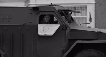 Movie still from “Belfast” (2021), directed by Kenneth Branagh – A black and white photo of a man in the window of an armored vehicle; Medium shot, Low angle