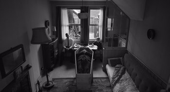 Movie still from “Belfast” (2021), directed by Kenneth Branagh – Two men are sitting at a table in a living room; Wide shot, High angle