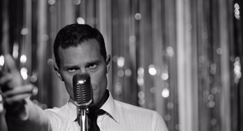 Movie still from “Belfast” (2021), directed by Kenneth Branagh – A black and white photo of a man with a microphone; Close Up shot, Low angle