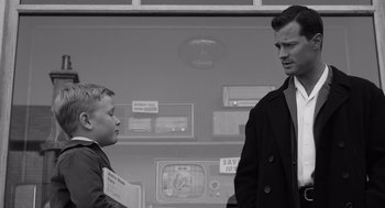 Movie still from “Belfast” (2021), directed by Kenneth Branagh – A man and a young boy standing next to each other; Medium shot, Over the shoulder angle