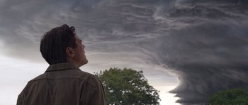 Movie still from “Take Shelter” (2011), directed by Jeff Nichols – A man looking up at a storm cloud in the sky; Medium shot, Low angle