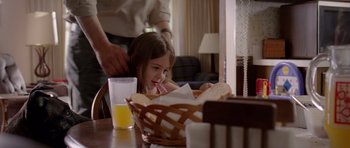 Movie still from “Take Shelter” (2011), directed by Jeff Nichols – A little girl sitting at a table with a basket of bread; Medium shot, Over the shoulder angle