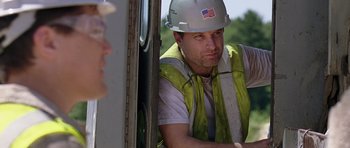 Movie still from “Take Shelter” (2011), directed by Jeff Nichols – A construction worker wearing a hard hat and safety vest; Medium shot, Over the shoulder angle