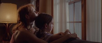 Movie still from “Take Shelter” (2011), directed by Jeff Nichols – A woman and a girl looking out a window; Medium shot, Low angle