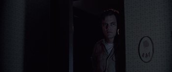 Movie still from “Take Shelter” (2011), directed by Jeff Nichols – A man standing in a dark room looking at the camera; Close Up shot, Low angle