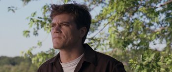 Movie still from “Take Shelter” (2011), directed by Jeff Nichols – A person wearing a brown shirt near a tree; Close Up shot, Low angle