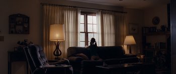 Movie still from “Take Shelter” (2011), directed by Jeff Nichols – A woman sitting on a couch looking out a window; Wide shot, Low angle