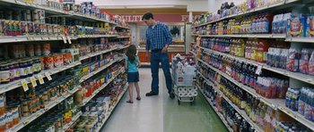 Movie still from “Take Shelter” (2011), directed by Jeff Nichols – A man and a little girl standing in a grocery store; Wide shot, High angle
