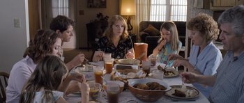 Movie still from “Take Shelter” (2011), directed by Jeff Nichols – A group of people sitting around a table eating food; Medium shot, High angle