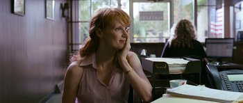 Movie still from “Take Shelter” (2011), directed by Jeff Nichols – A woman sitting at a desk with her head resting on her hand; Medium shot, Over the shoulder angle