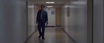 Movie still from “Take Shelter” (2011), directed by Jeff Nichols – A man walking down a hallway in a building; Wide shot, Low angle