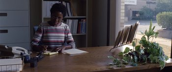 Movie still from “Take Shelter” (2011), directed by Jeff Nichols – A woman sitting at a table reading a book; Medium shot, High angle