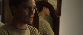 Movie still from “Take Shelter” (2011), directed by Jeff Nichols – A man standing in front of a mirror with a string of pearls; Close Up shot, Low angle