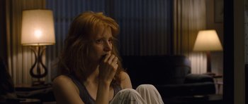 Movie still from “Take Shelter” (2011), directed by Jeff Nichols – A woman sitting on the ground with her hand in her mouth; Close Up shot, High angle