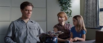 Movie still from “Take Shelter” (2011), directed by Jeff Nichols – A man and two women sitting at a table; Medium shot, Over the shoulder angle