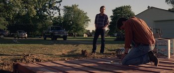 Movie still from “Take Shelter” (2011), directed by Jeff Nichols – A man standing in the grass next to a truck; Wide shot, Low angle