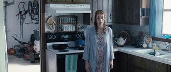 Movie still from “Take Shelter” (2011), directed by Jeff Nichols – A woman standing in a kitchen next to an oven; Medium shot, Over the shoulder angle