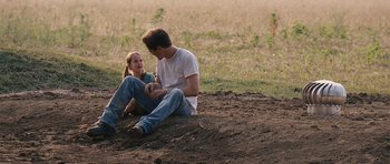Movie still from “Take Shelter” (2011), directed by Jeff Nichols – A man and a woman sitting on the ground; Wide shot, Over the shoulder angle