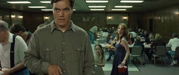 Movie still from “Take Shelter” (2011), directed by Jeff Nichols – A group of people in a room with a man holding a red cup; Medium shot, Over the shoulder angle