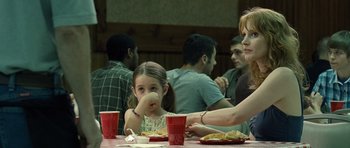 Movie still from “Take Shelter” (2011), directed by Jeff Nichols – A girl sitting at a table with a plate of food in front of her; Medium shot, Over the shoulder angle