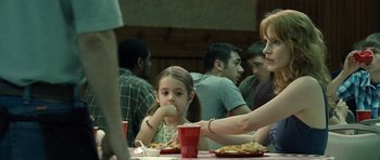 Movie still from “Take Shelter” (2011), directed by Jeff Nichols – A group of people sitting at a table eating food; Medium shot, Over the shoulder angle