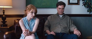Movie still from “Take Shelter” (2011), directed by Jeff Nichols – A man and a woman sitting next to each other on a couch; Medium shot, Over the shoulder angle