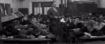 Movie still from “The 400 Blows” (1959), directed by François Truffaut – An old photo of a man standing in front of a group of students; Medium shot, High angle