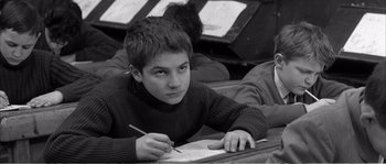 Movie still from “The 400 Blows” (1959), directed by François Truffaut – A young boy is writing on a piece of paper; Close Up shot, High angle