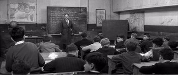Movie still from “The 400 Blows” (1959), directed by François Truffaut – An old photo of a man teaching a class; Wide shot, High angle