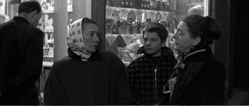 Movie still from “The 400 Blows” (1959), directed by François Truffaut – A group of people standing next to each other in front of a window; Medium shot, Over the shoulder angle
