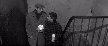 Movie still from “The 400 Blows” (1959), directed by François Truffaut – Two men standing next to each other on the stairs; Medium shot, High angle