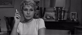 Movie still from “The 400 Blows” (1959), directed by François Truffaut – A black - and - white photo of a woman sitting in a living room; Close Up shot, Over the shoulder angle