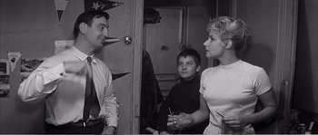 Movie still from “The 400 Blows” (1959), directed by François Truffaut – A group of people standing next to each other in a room; Medium shot, Over the shoulder angle