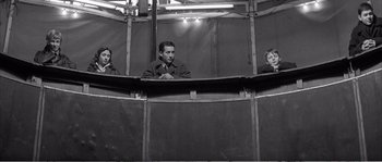 Movie still from “The 400 Blows” (1959), directed by François Truffaut – Three men are sitting in an enclosed area; Medium shot, Low angle