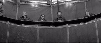Movie still from “The 400 Blows” (1959), directed by François Truffaut – A man and a woman sitting in front of each other in front of an audience; Medium shot, High angle
