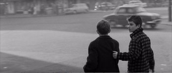 Movie still from “The 400 Blows” (1959), directed by François Truffaut – A young boy is walking down the street; Medium shot, Over the shoulder angle