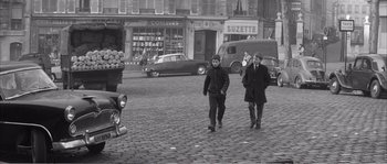 Movie still from “The 400 Blows” (1959), directed by François Truffaut – Two men walking down a street in a city; Wide shot, High angle