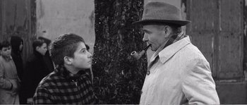 Movie still from “The 400 Blows” (1959), directed by François Truffaut – An older man and a young boy talking to each other; Medium shot, Over the shoulder angle