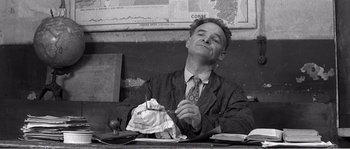 Movie still from “The 400 Blows” (1959), directed by François Truffaut – A man sitting at a table holding a knife in his hand; Medium shot, Low angle